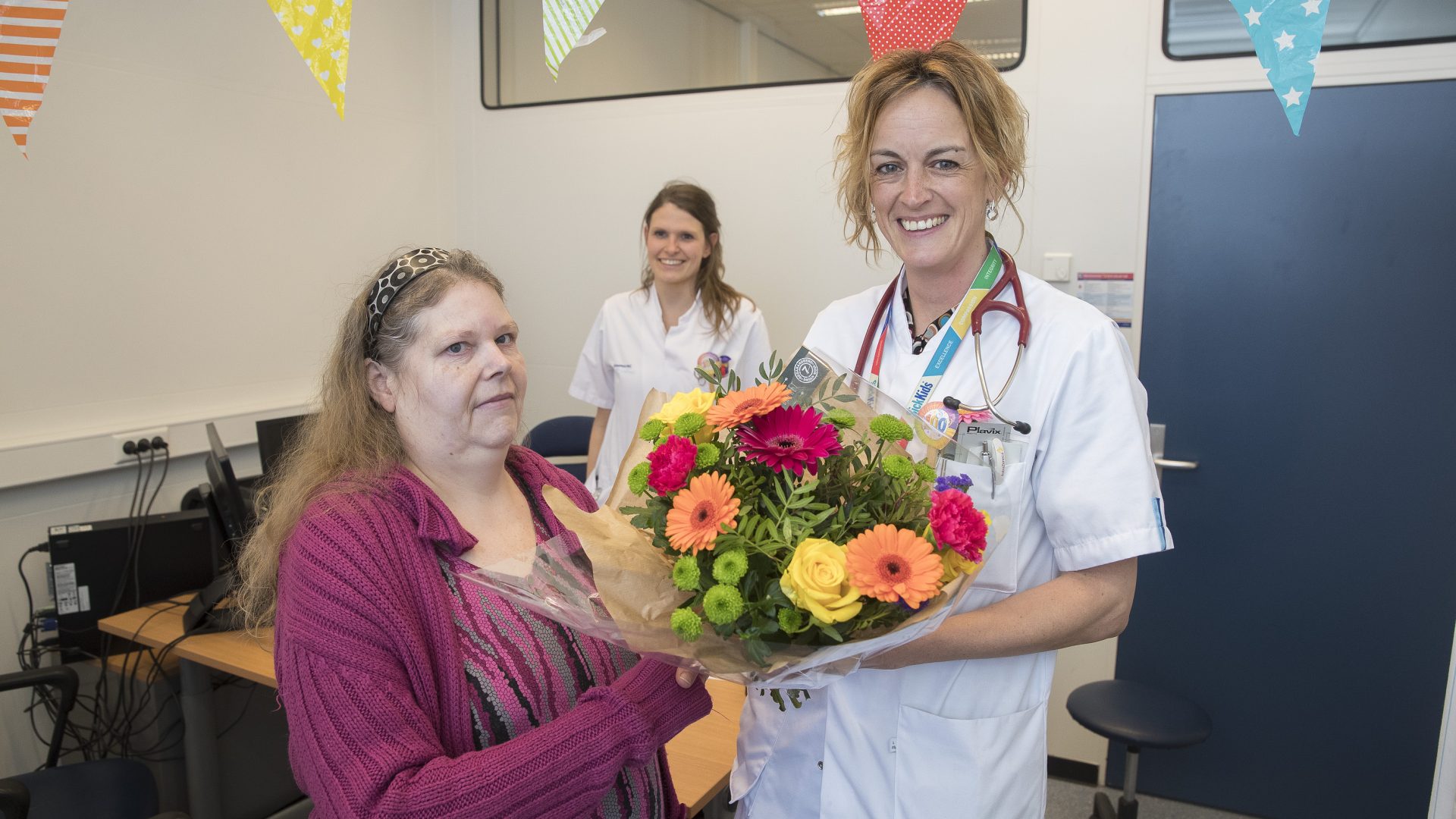 Internist-endocrinoloog dr. Laura de Graaff-Herder overhandigt bloemen aan de honderdste Prader-Willi-patiënt